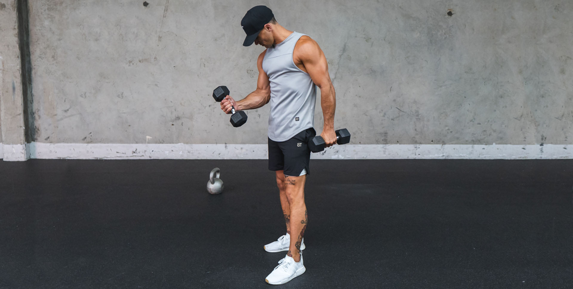 młoda kobieta robi burpees na gumowej macie w sali CrossFit z lustrami